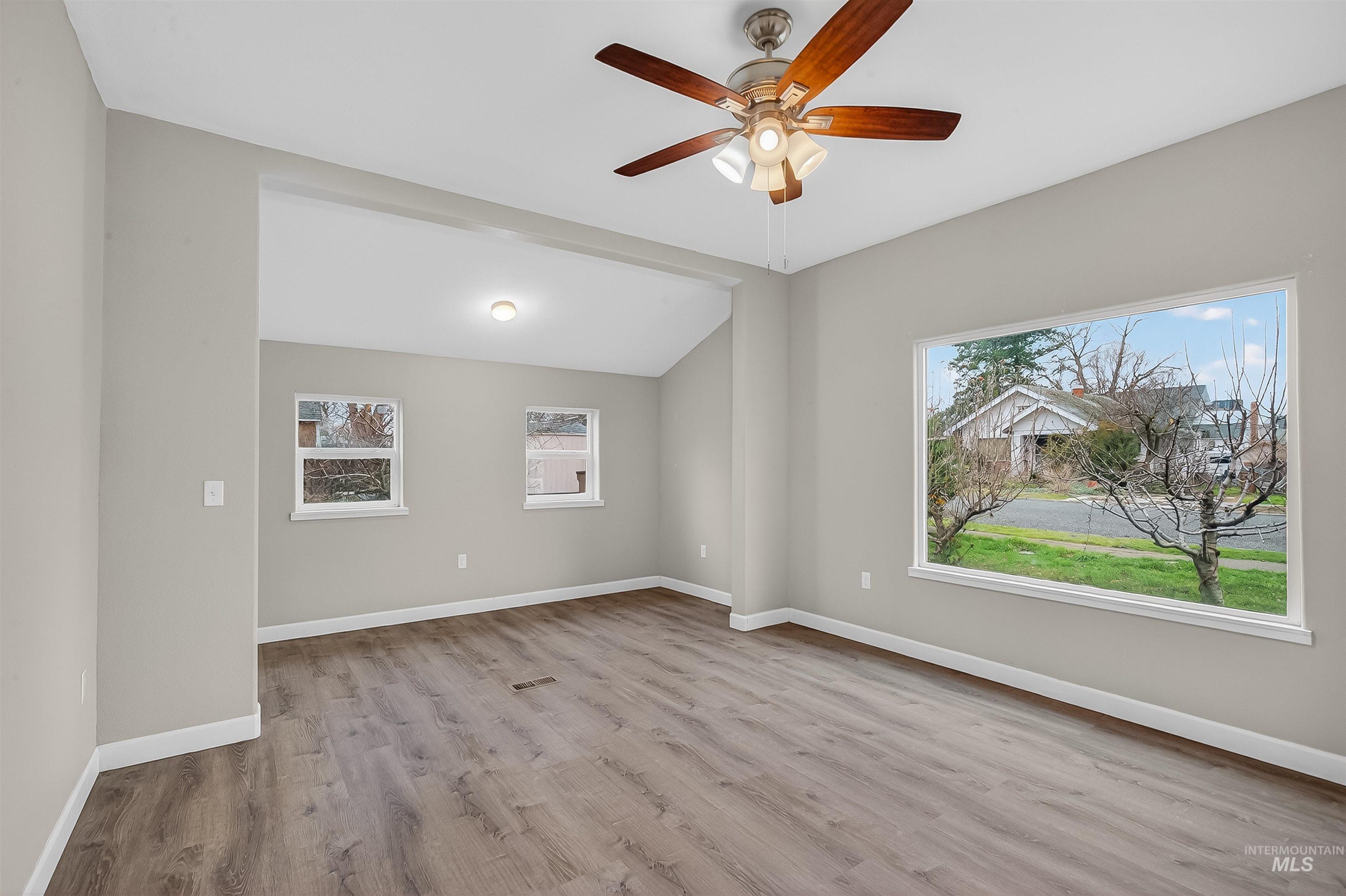 833 8th Street Clarkston, WA 99403 - Photo 5 of 40 Empty room featuring light wood-type flooring, lofted ceiling, and a ceiling fan