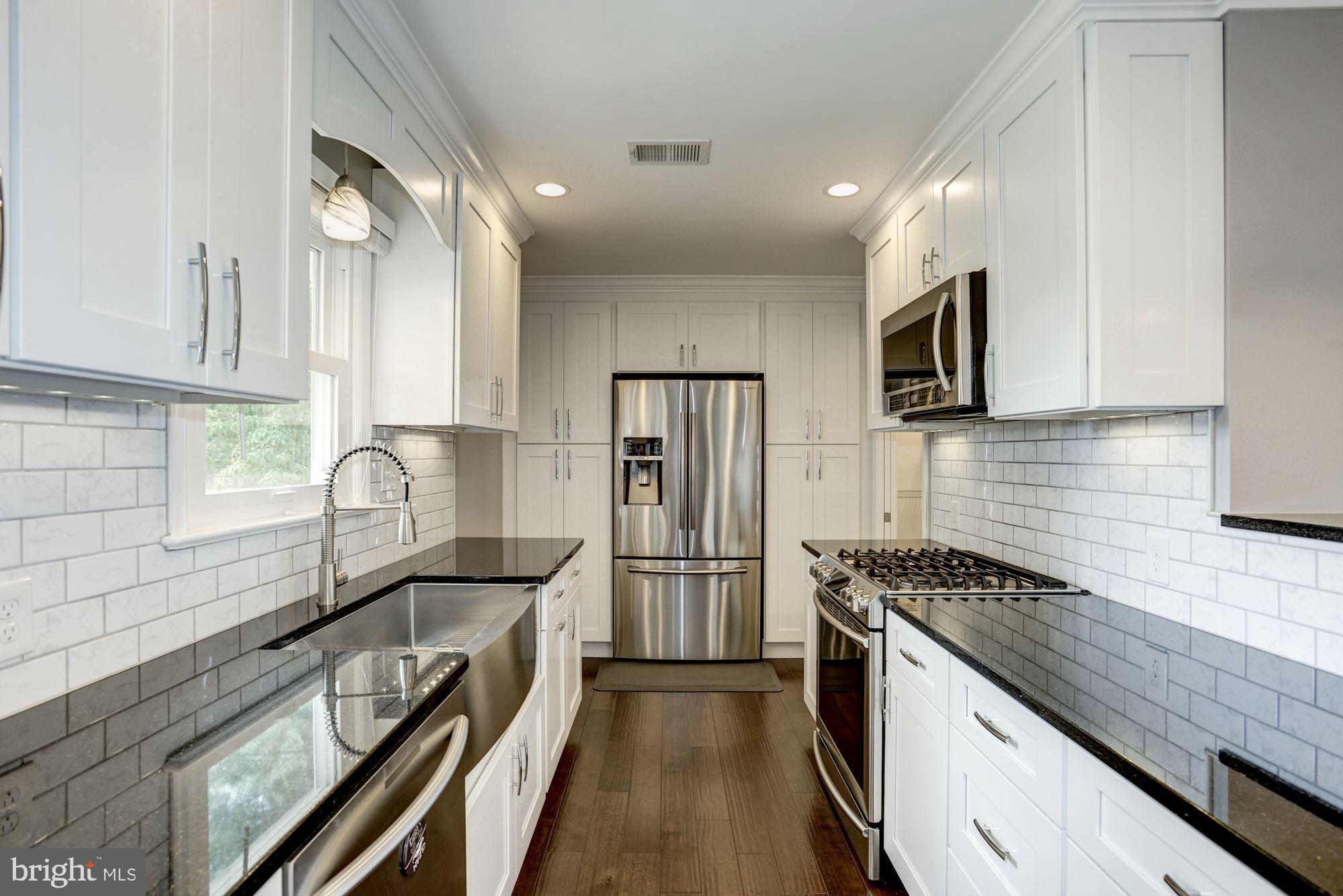 a kitchen with stainless steel appliances a sink dishwasher a refrigerator a stove top oven a sink and dishwasher