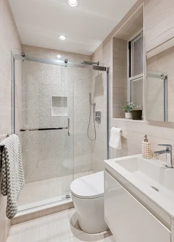 a bathroom with a sink a toilet mirror and shower