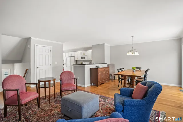 a living room with furniture kitchen view and a chandelier