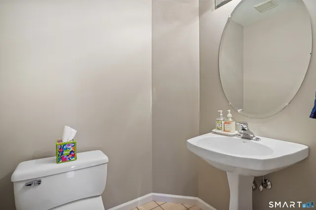 a bathroom with a sink toilet and a mirror