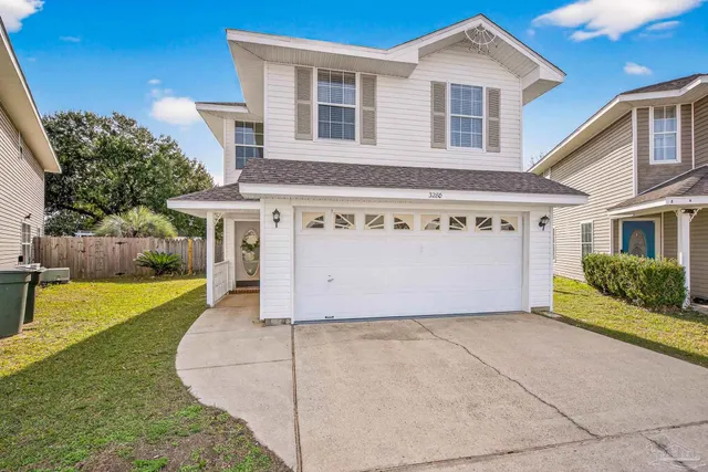 a front view of a house with a yard and potted plants