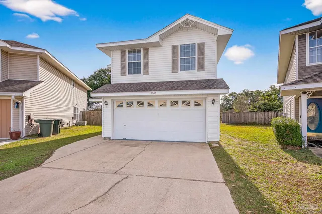 a view of a house with a yard and potted plants
