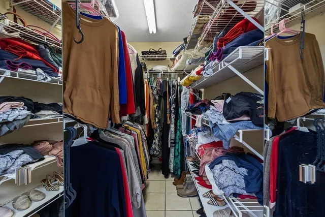 a view of walk in closet with clothes and shoes