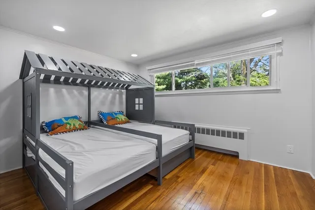 a bed sitting in a bedroom next to a window