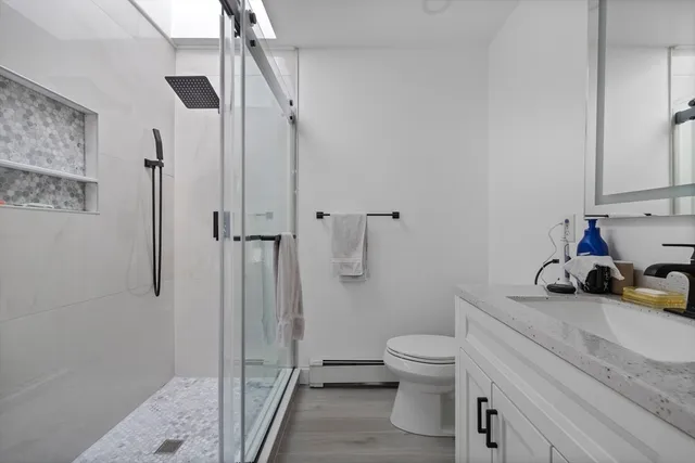 a bathroom with a sink a toilet and shower