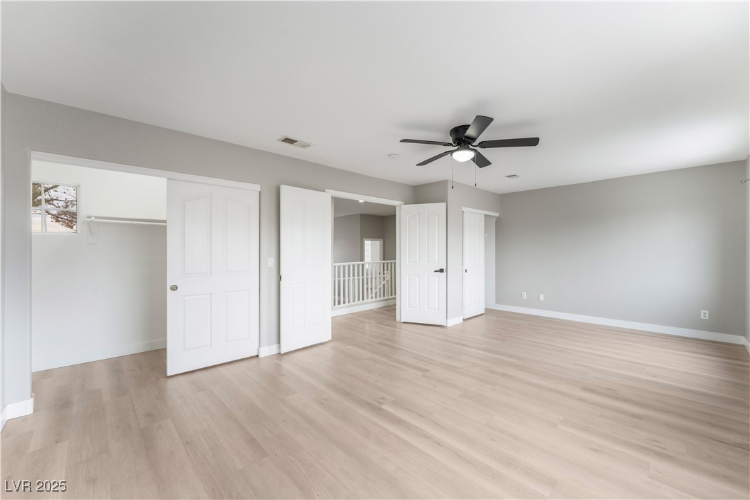 3695 Funston Way Las Vegas, NV 89129 - Photo 28 of 43 Unfurnished bedroom featuring light wood-style floors, ceiling fan, and two closets