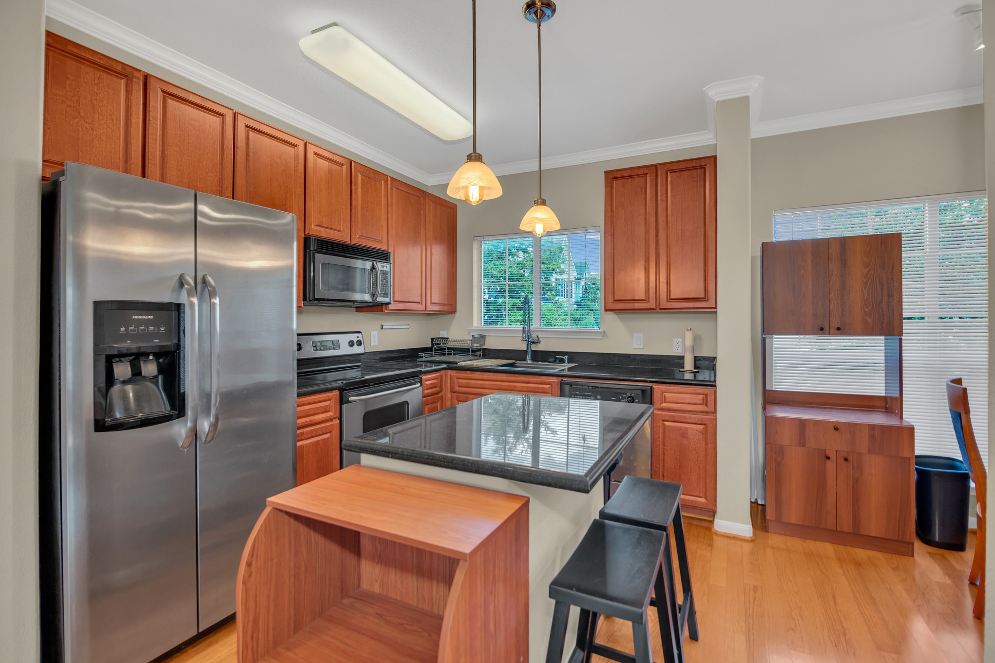 9200 Westheimer Road, Unit 1503 Houston, TX 77063 - Photo 12 of 37 a kitchen with stainless steel appliances granite countertop a refrigerator a sink dishwasher a stove and a dining table with wooden floor