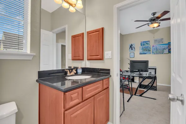 a bathroom with a granite countertop sink a toilet and a mirror