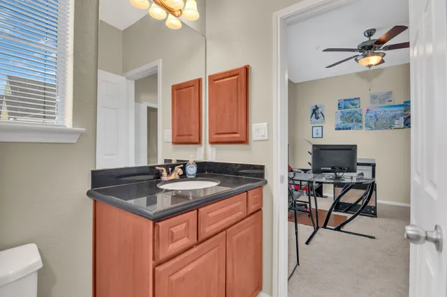 a bathroom with a granite countertop sink a toilet and a mirror