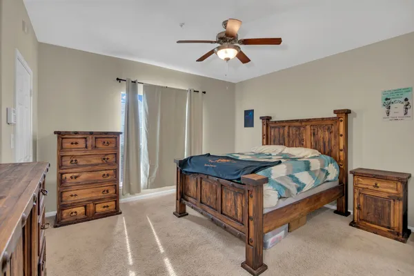a bedroom with a bed and a ceiling fan