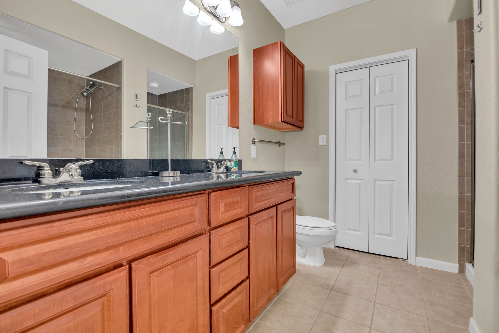 9200 Westheimer Road, Unit 1503 Houston, TX 77063 - Photo 27 of 37 a spacious bathroom with a granite countertop sink a toilet and a mirror