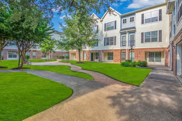 a view of a big yard in front of a brick house