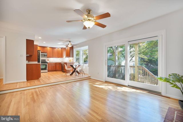 a kitchen with stainless steel appliances kitchen island granite countertop a stove top oven a sink dishwasher a dining table and chairs with wooden floor
