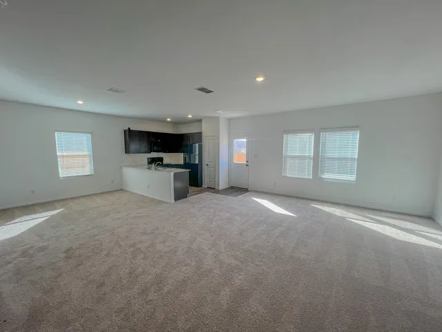 an empty room with a fireplace and windows