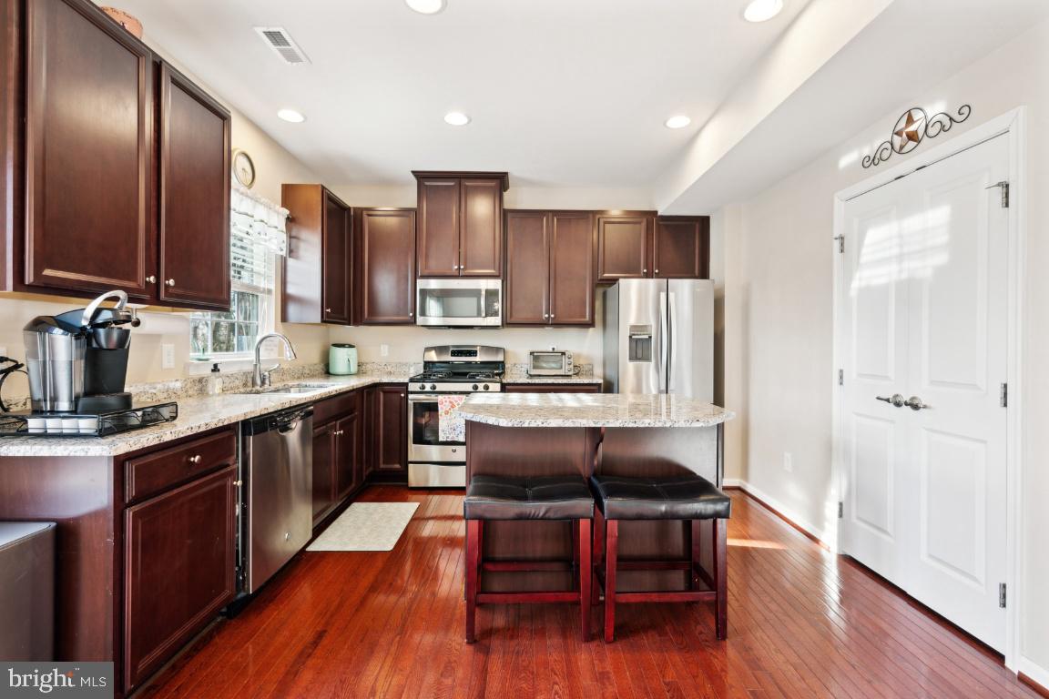 12 Wallace Road Mount Holly, NJ 08060 - Photo 1 of 25 a kitchen with kitchen island granite countertop wooden floors stainless steel appliances a sink and cabinets