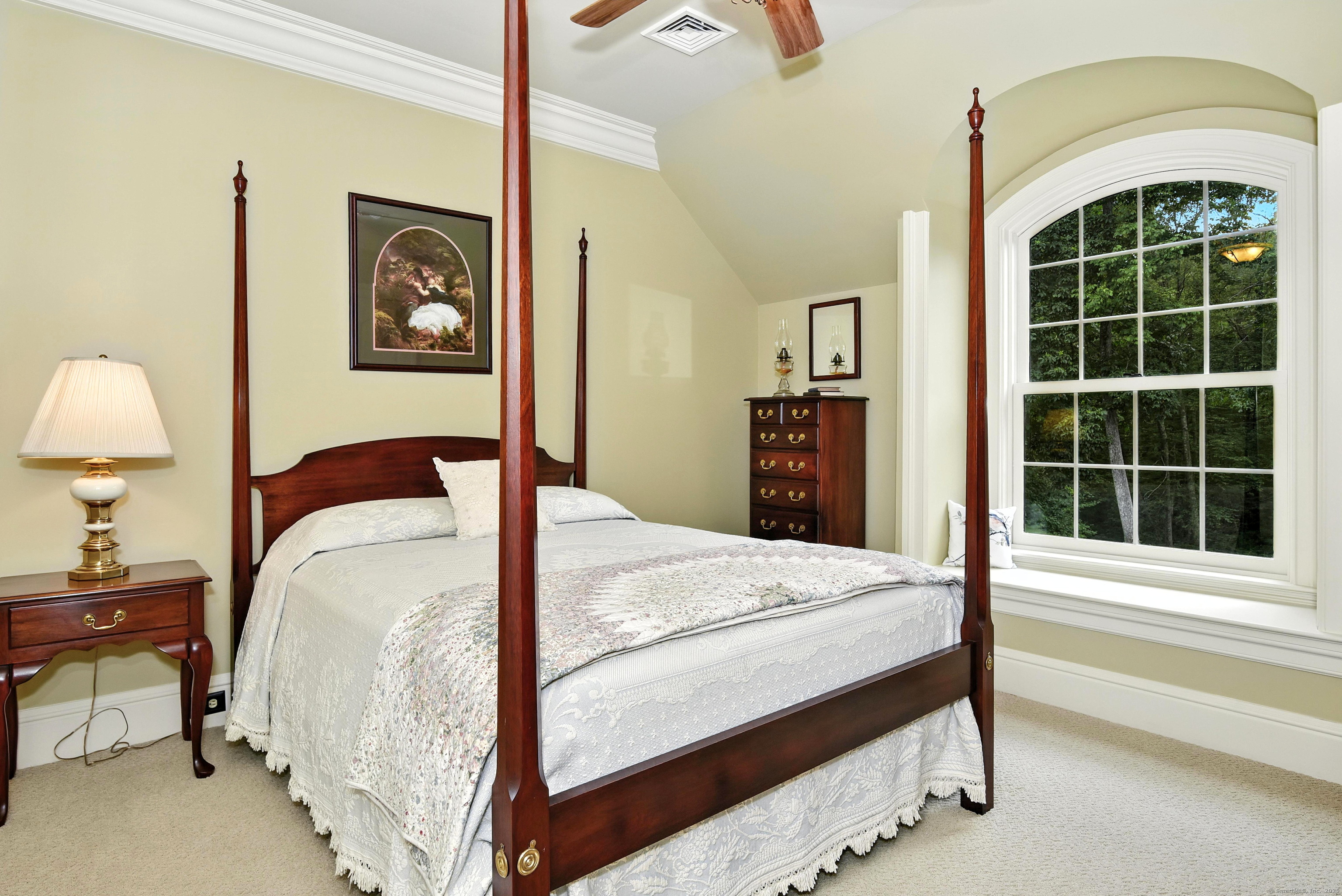 282 Searles Road Pomfret, CT 06259 - Photo 25 of 40 The westerly view 3rd bedroom features a spacious walk-in closet and timeless architectural details. An arched double-hung window, framed with wide casing and a deep sill, creates a charming window seat nook.