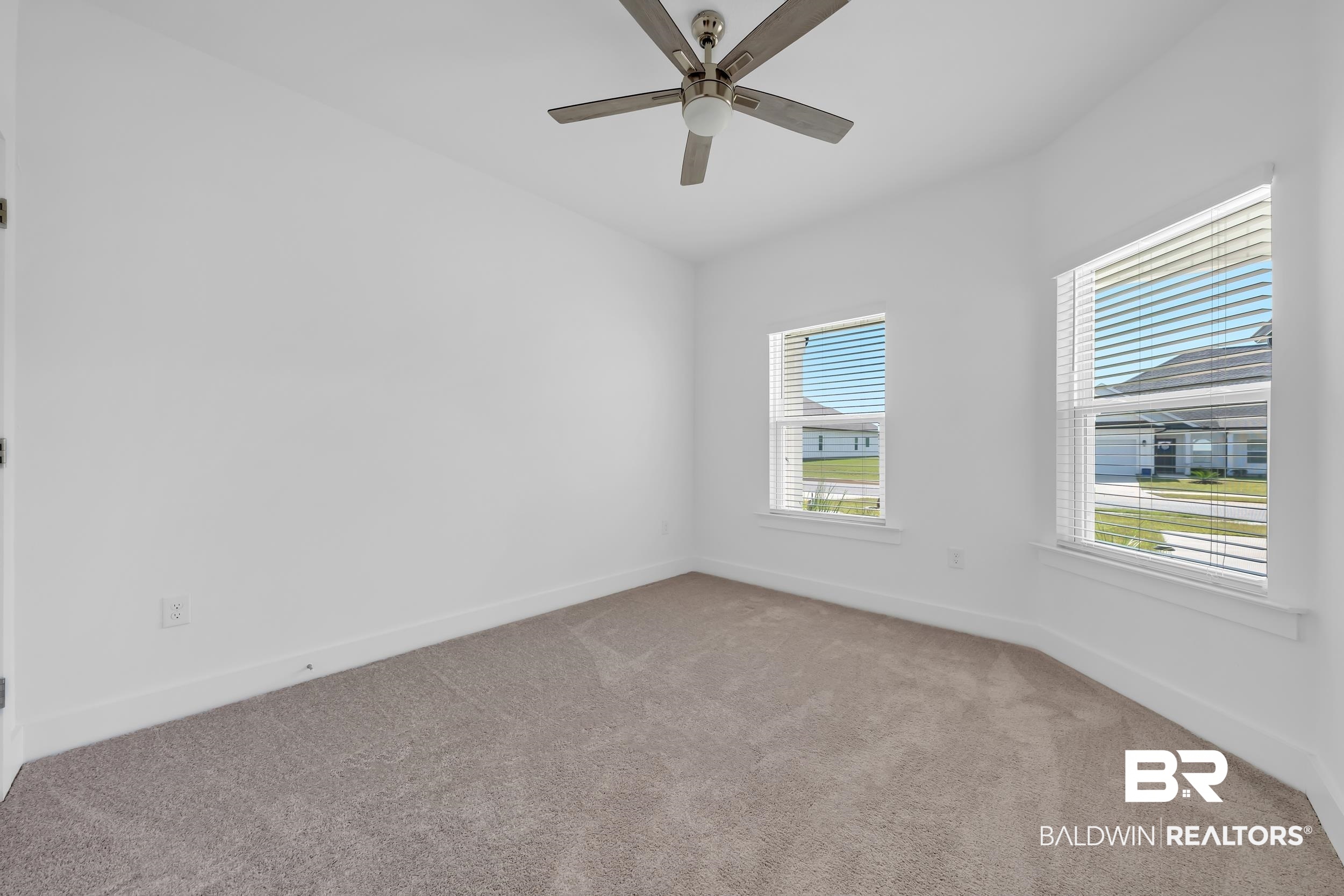 9933 Weller Cove Foley, AL 36535 - Photo 21 of 36 Bright room featuring two windows with horizontal blinds, a ceiling fan with brushed nickel accents, and neutral carpet flooring