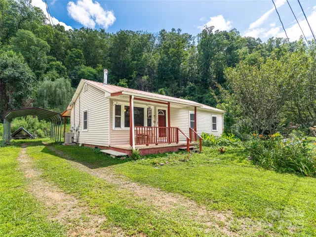 a aerial view of a house next to a big yard and large trees
