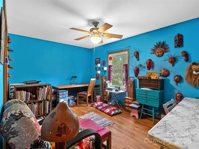 a living room with furniture and a baby crib