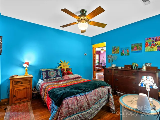 a bedroom with a bed and wooden floor