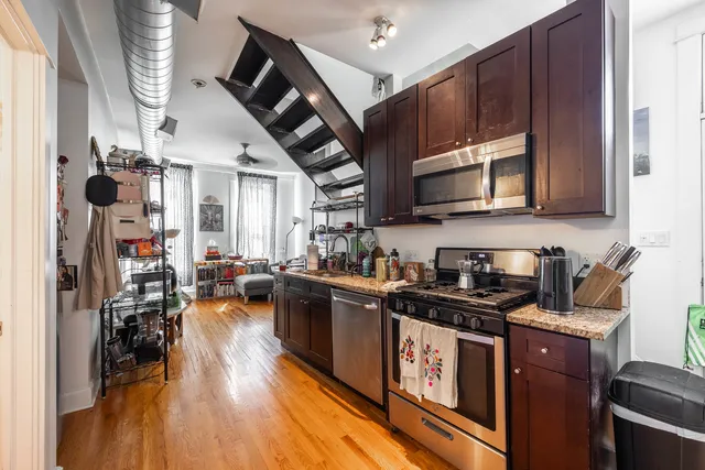 a kitchen with stainless steel appliances granite countertop a sink a stove and a refrigerator