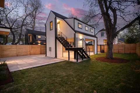a view of house with backyard and trees