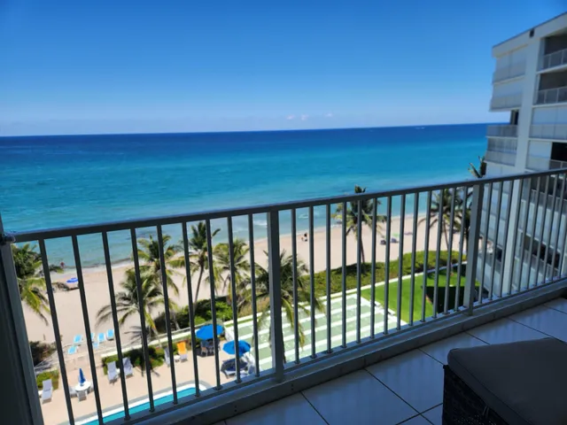 a view of a swimming pool with a lawn chairs under an umbrella
