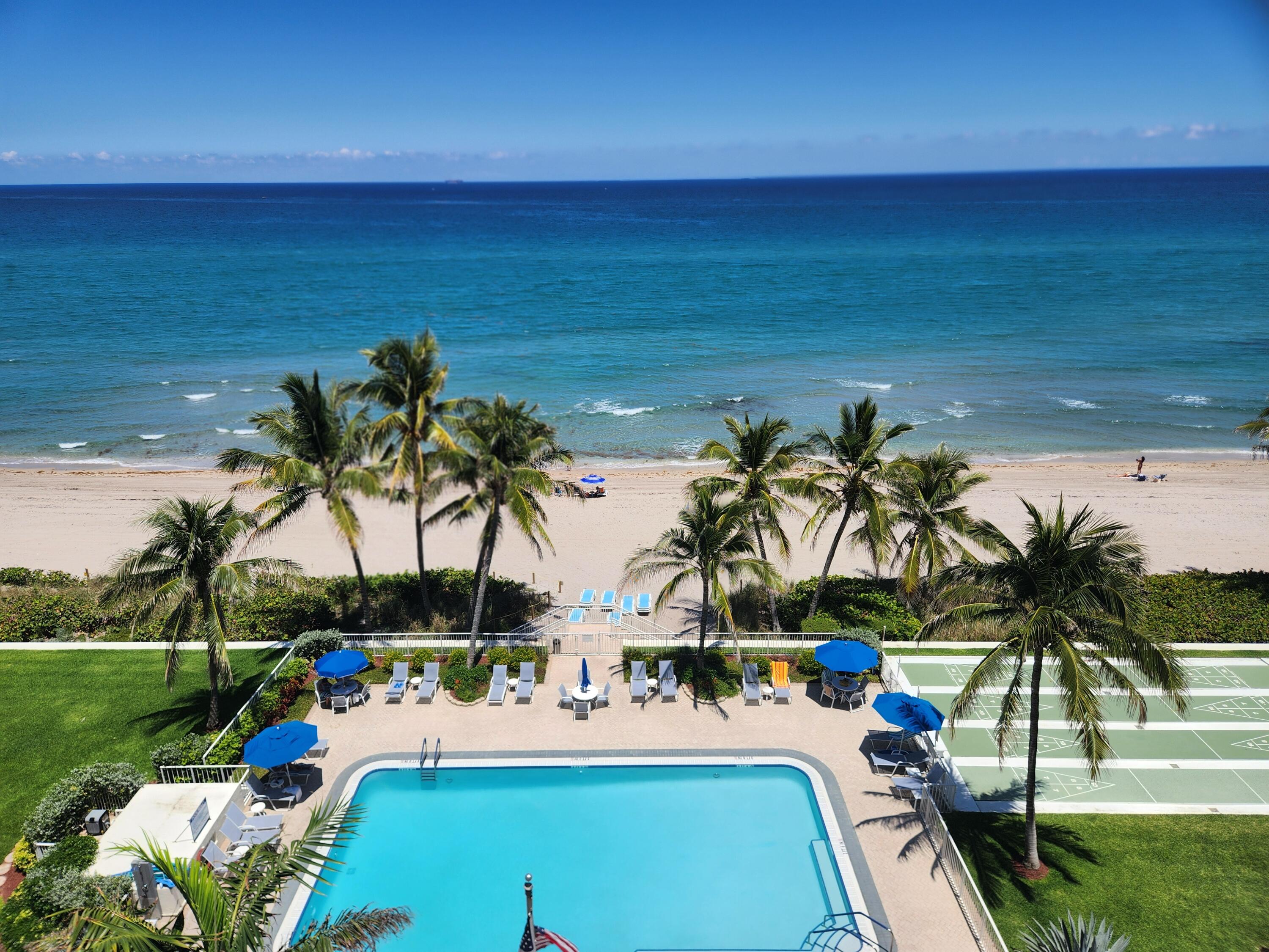 3101 South Ocean Boulevard, Unit 812 Highland Beach, FL 33487 - Photo 20 of 24 a view of a swimming pool with a lawn chairs under an umbrella
