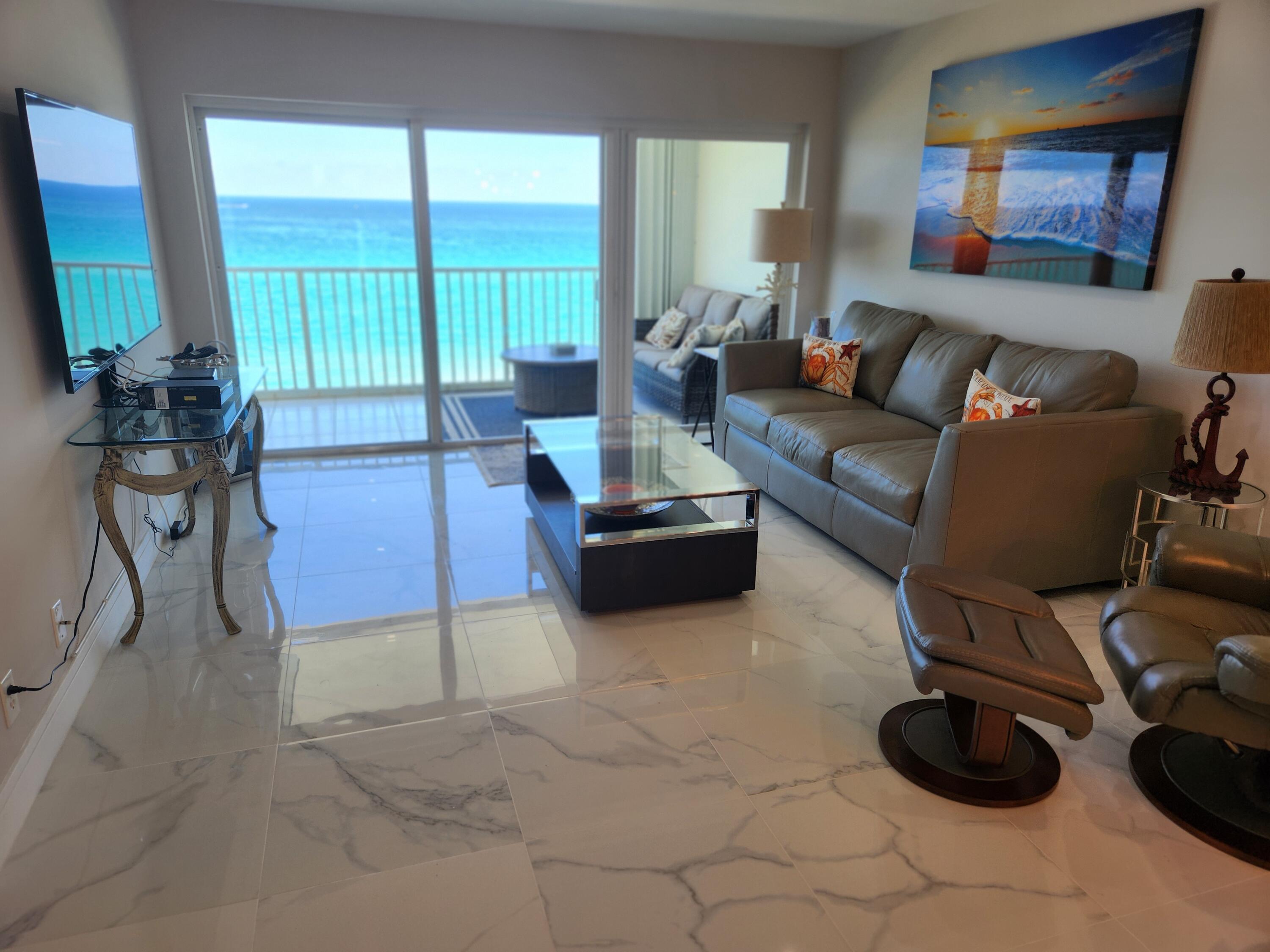 3101 South Ocean Boulevard, Unit 812 Highland Beach, FL 33487 - Photo 7 of 24 a living room with furniture a large window and a flat screen tv