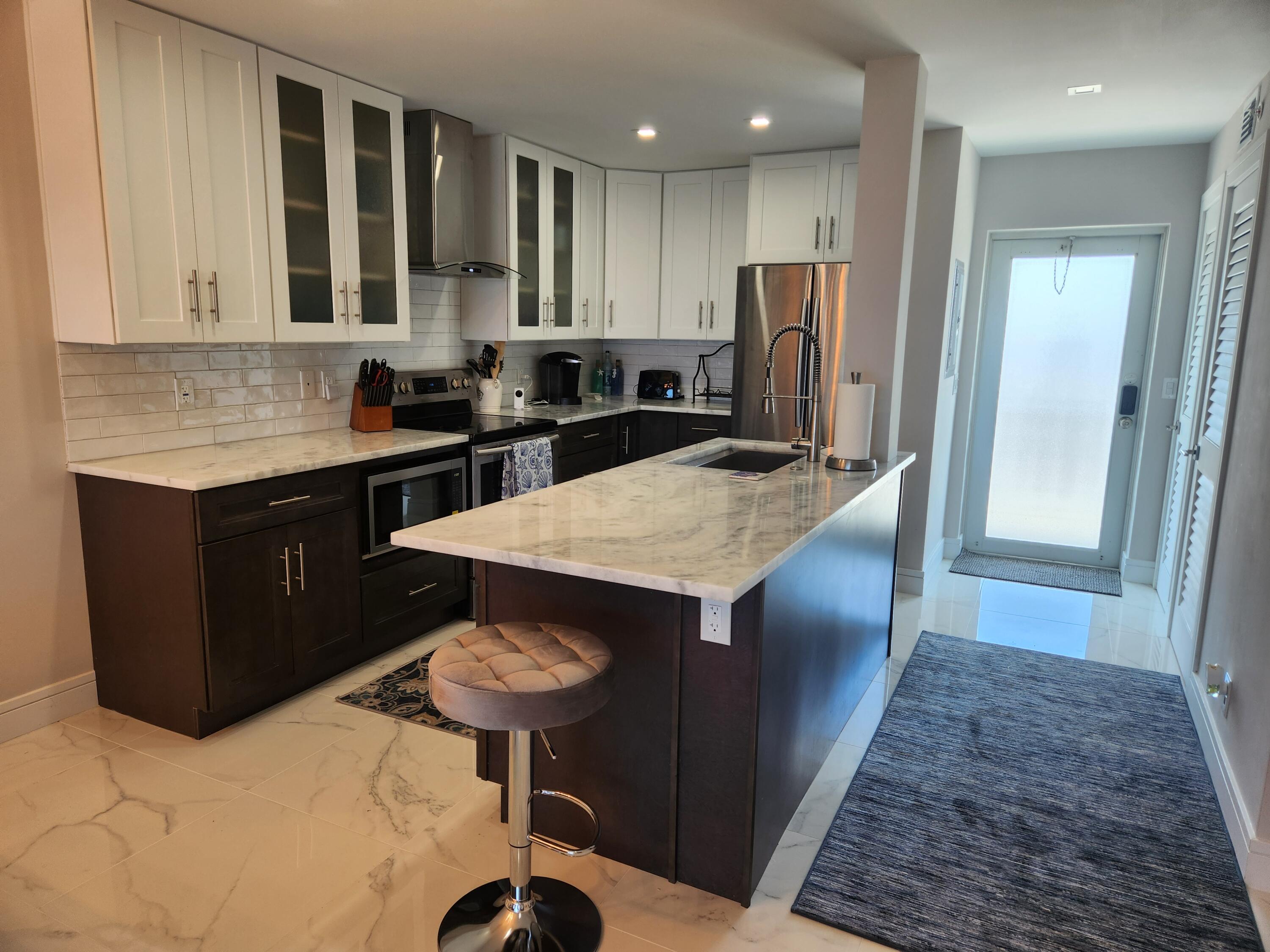 3101 South Ocean Boulevard, Unit 812 Highland Beach, FL 33487 - Photo 8 of 24 a kitchen with stainless steel appliances granite countertop a sink a stove and a refrigerator