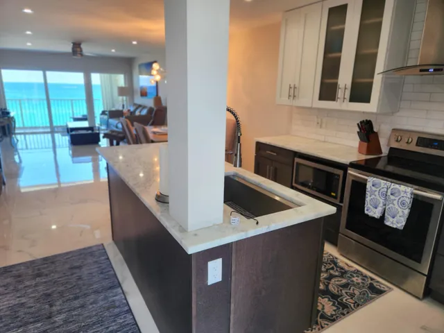 a kitchen with stainless steel appliances granite countertop a sink and a stove