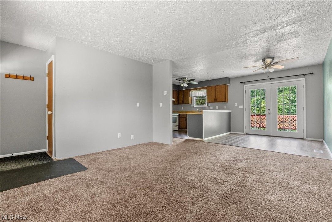 1827 Barth Road Belpre, OH 45714 - Photo 10 of 31 Carpeted living room with ceiling fan and a textured ceiling