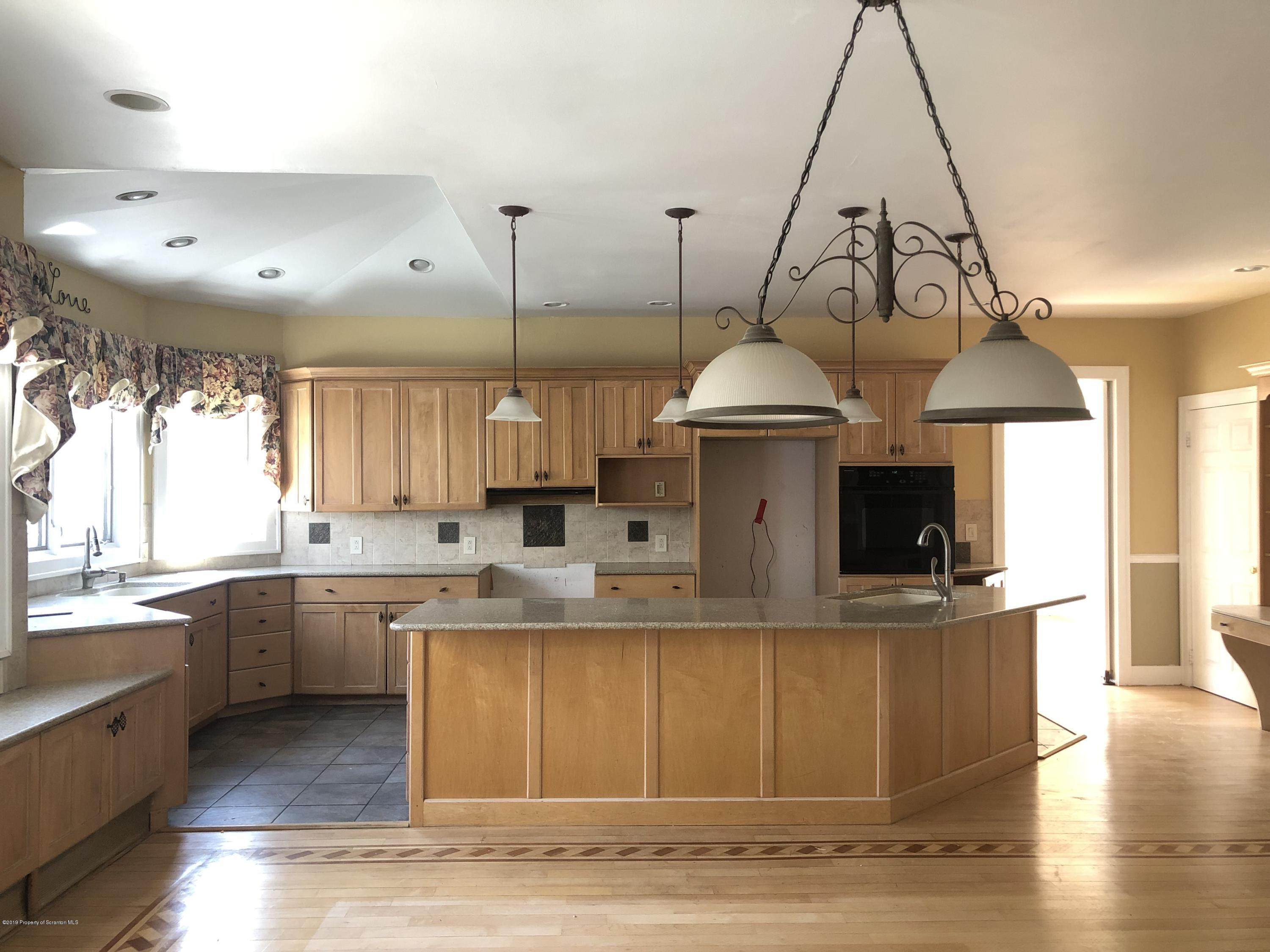 105 Noble Road Clarks Summit, PA 18411 - Photo 4 of 11 a kitchen with stainless steel appliances granite countertop a sink a stove and a wooden floors