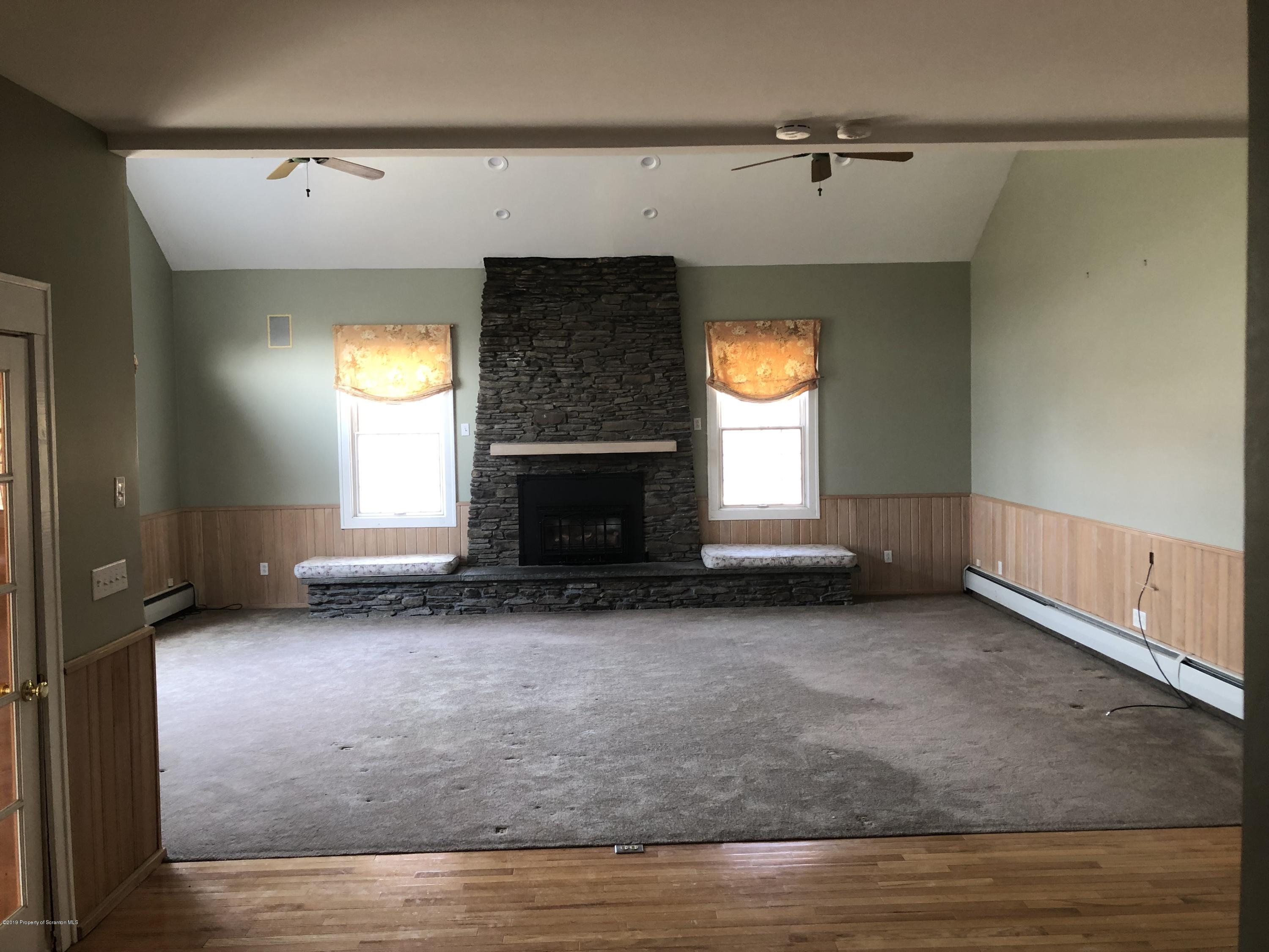 105 Noble Road Clarks Summit, PA 18411 - Photo 9 of 11 an empty room with windows and fireplace