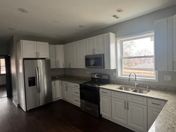 a kitchen with appliances a sink and a window