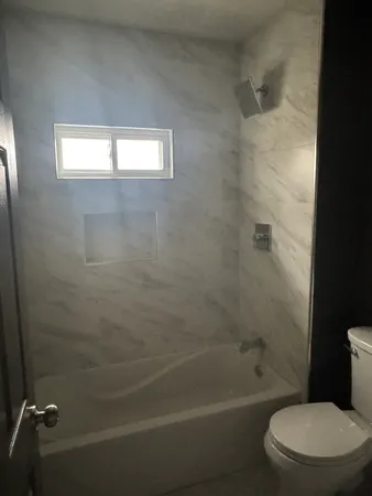 a bathroom with a toilet and a tub