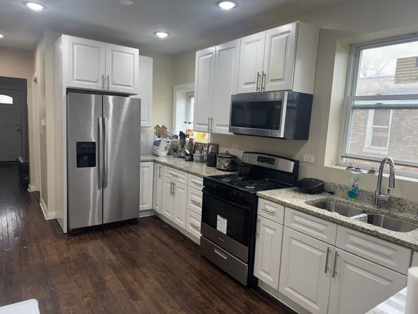 a kitchen with stainless steel appliances granite countertop a refrigerator sink and microwave