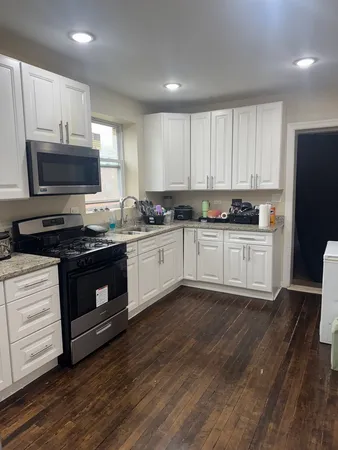 a kitchen with granite countertop a sink cabinets and stainless steel appliances