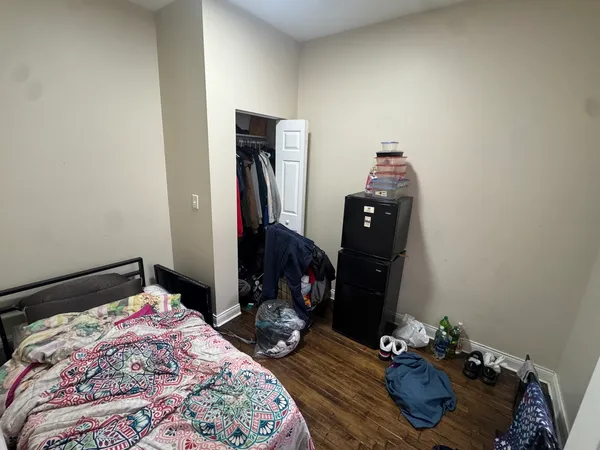 a bedroom with a bed and wooden floor