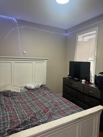 a bedroom with a bed and flat screen tv