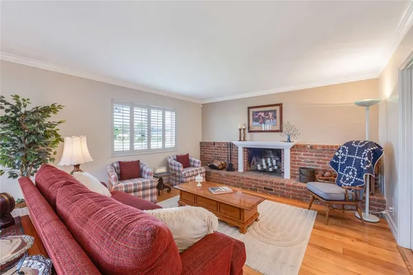 a living room with furniture a fireplace and potted plants