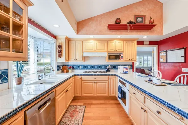 a large kitchen with stainless steel appliances granite countertop a large window and a sink