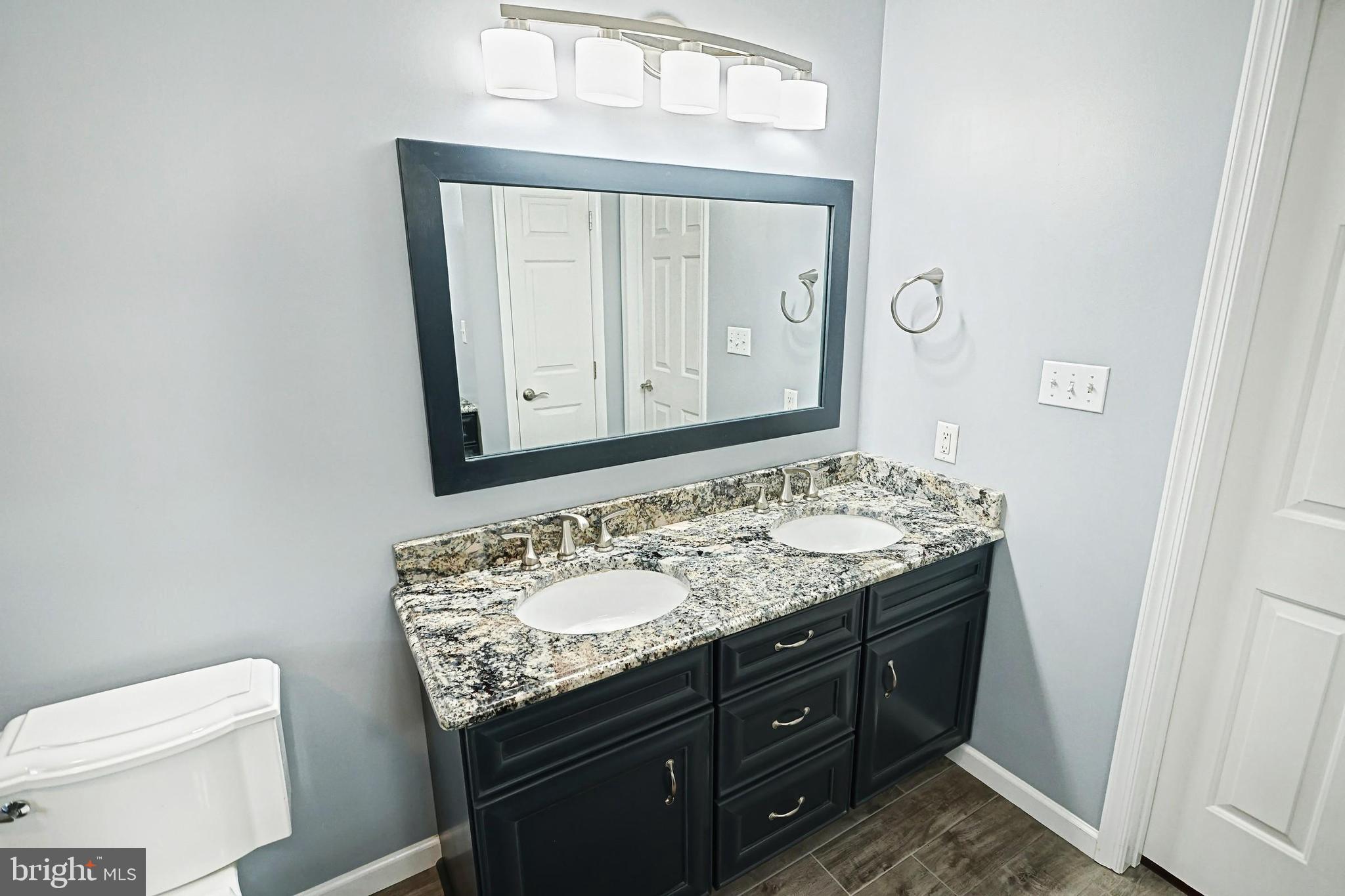 645 Kindig Road Littlestown, PA 17340 - Photo 41 of 61 a bathroom with a granite countertop toilet sink and mirror