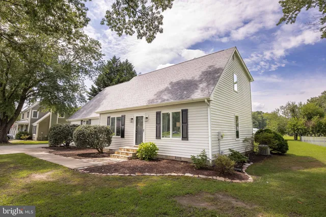 a view of a house with a yard and tree s