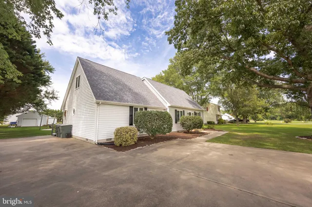 a front view of a house with a garden and trees
