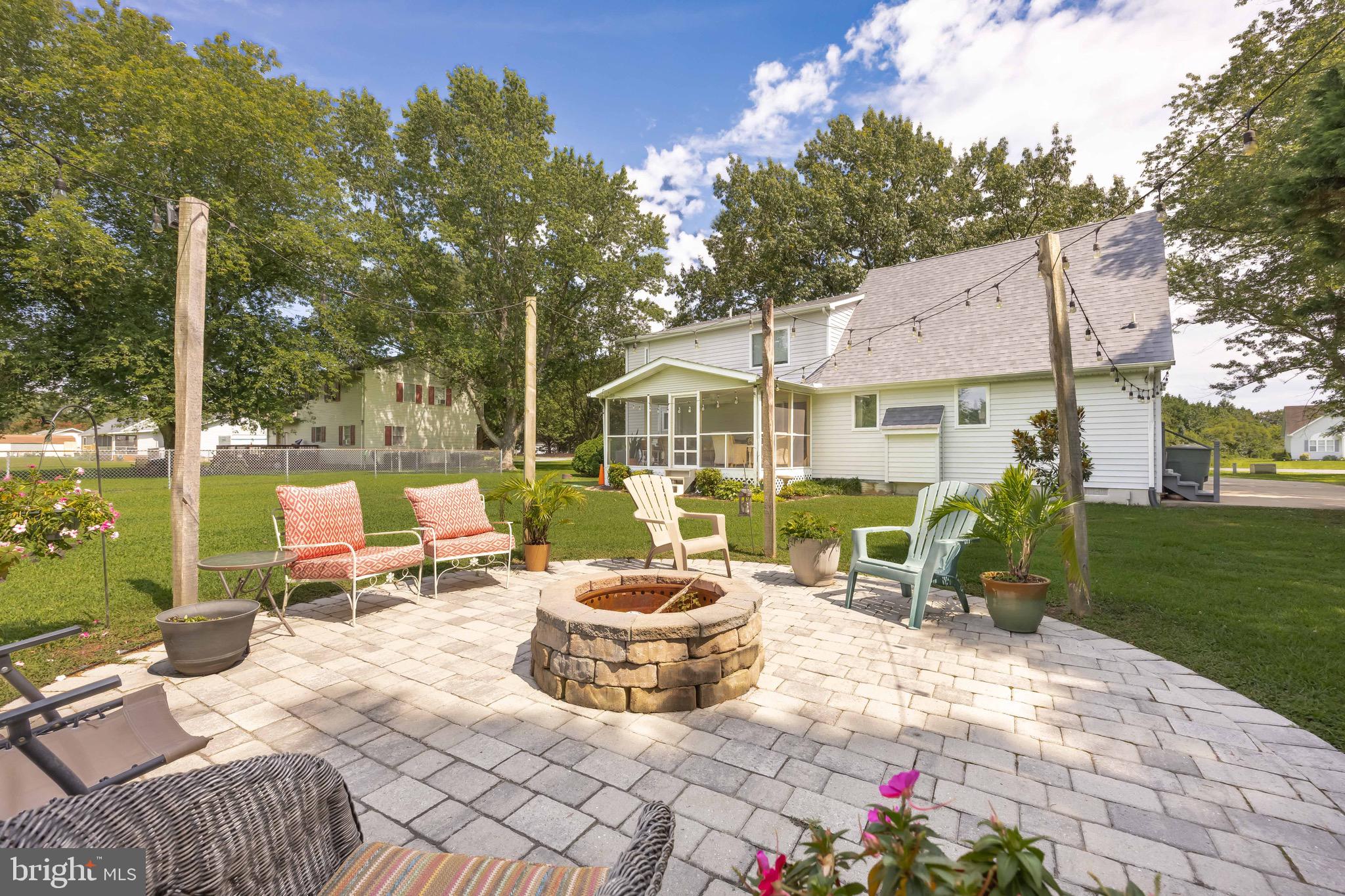 26882 Pratt Road Salisbury, MD 21801 - Photo 63 of 80 a view of a patio with a dining table and chairs with a fire pit
