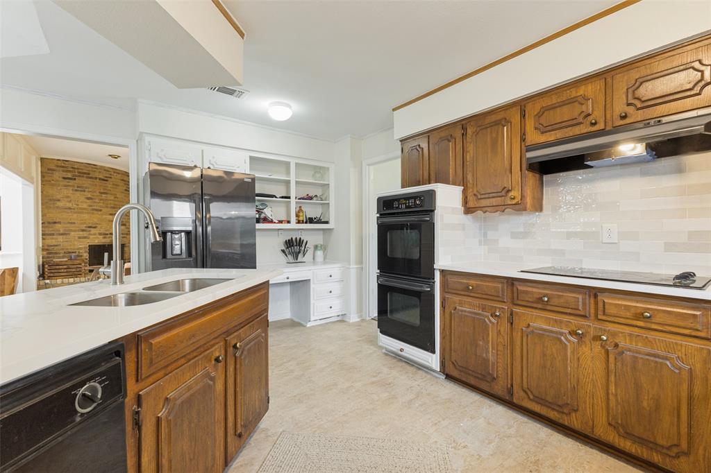 705 South Grove Road Richardson, TX 75081 - Photo 15 of 26 Kitchen featuring wood cabinetry, light-toned countertops, and a subway tile backsplash