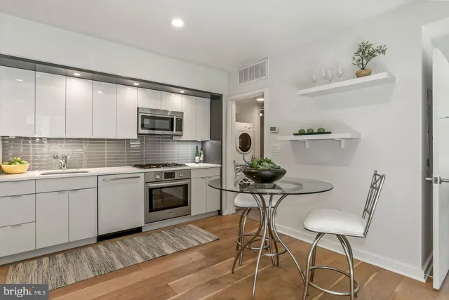 a kitchen with stainless steel appliances kitchen island granite countertop a sink and cabinets