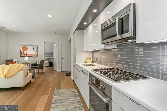 a kitchen with stainless steel appliances kitchen island granite countertop a stove and a sink